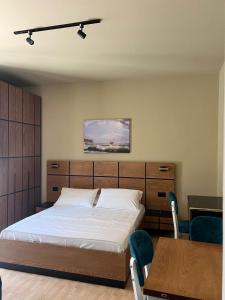 ZverneciVilla Shehu的一间卧室，里面有一张床、一张桌子和几把椅子。