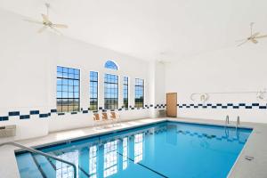 a large swimming pool with chairs in a building at Best Western StateLine Lodge in West Siloam Springs