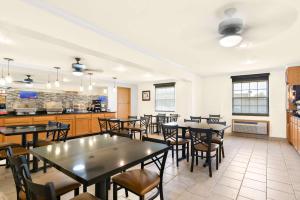 a dining room with tables and chairs and a kitchen at Best Western StateLine Lodge in West Siloam Springs