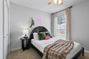 a bedroom with a bed with green pillows and a window at Steps to the beach & close to 30A! Private pool with sundeck & putt putt golf! in Panama City Beach +65 photos