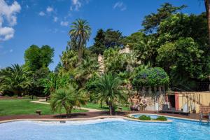 a resort with a swimming pool and palm trees at Hotel Villa Retiro in Xerta