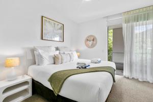 Un dormitorio blanco con una cama grande y una ventana. en Coastal Harbour Lights I Pool, Gym & prime Location, en Cairns 18 fotos más