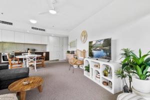 una sala de estar con un sofá y una mesa en Coastal Harbour Lights I Pool, Gym & prime Location, en Cairns