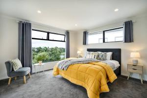 a bedroom with a yellow bed and a window at Riverview Retreat-4 bedrooms Brand New House In Hamilton in Hamilton
