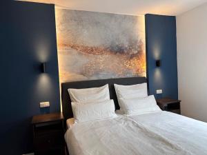 a bedroom with a bed with a painting on the wall at City Apartment with WIFI, Kitchen and 4K TV in Essen