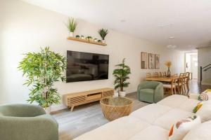 a living room with a couch and chairs and a tv at 4 Bedroom 3 Full Bath Boho Oasis Saltwater Pool Near Downtown, North of Hyde Park Sleeps 12 Pets OK in Tampa