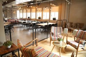 a large room with tables and chairs in a restaurant at The Post Hostel Jerusalem in Jerusalem