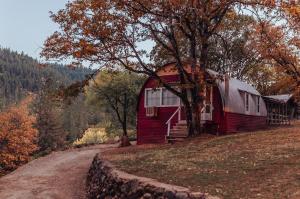 a red barn on a hill next to a tree at Lakeview Terrace Resort in Lewiston