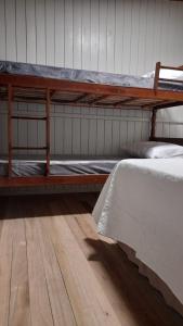 a bedroom with two bunk beds and a wooden floor at Pousada Luar dos Campos in Bom Jardim da Serra