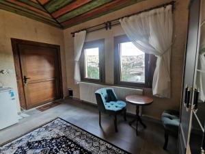 a room with a table and a chair and a window at Falcon Cave Suites in Göreme