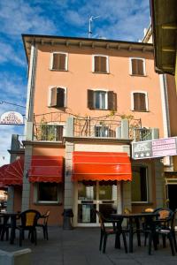 un edificio con tavoli e sedie di fronte ad esso di Hotel San Marco a Bedonia