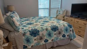 a bedroom with a bed with a flowered blanket at 2BR/2BA condo Sienna Park in Sarasota +23 photos
