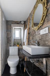 a bathroom with a white toilet and a mirror at Casa da Carqueija in Valezim +14 photos