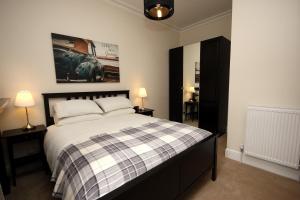 ein Schlafzimmer mit einem Bett, zwei Lampen und einem Gemälde in der Unterkunft Hamish's Hame Edinburgh Licence No EH 69774 R Energy Rating C in Edinburgh