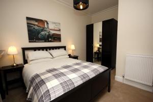 エディンバラにあるHamish's Hame Edinburgh Licence No EH 69774 Pのベッドルーム1室(ベッド1台、ランプ2つ、絵画付)