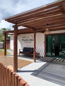 une pergola en bois avec un banc sur une terrasse dans l'établissement Pousada Portal da Atalaia, à Fernando de Noronha