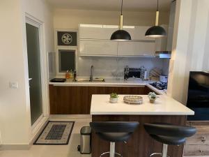 a kitchen with a counter and two stools at The Bliss Central - Elysium Tower Opp Centaurus Mall in Islamabad