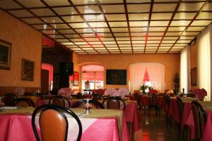 ein Esszimmer mit Tischen und Stühlen sowie einem rosa Tischtuch in der Unterkunft Hotel San Marco in Bedonia