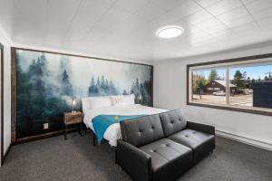 una camera da letto con un letto, un divano e un grande dipinto di Lazy Duck Inn a West Yellowstone