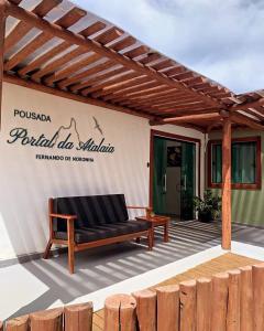 un banc sous une pergola en bois sur une terrasse dans l'établissement Pousada Portal da Atalaia, à Fernando de Noronha