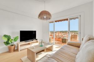 a living room with a couch and a tv at Sea View Penthouse in Vilanova i la Geltrú