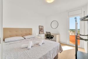 a white bedroom with a bed and a desk at Sea View Penthouse in Vilanova i la Geltrú