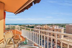 a balcony with chairs and a view of a city at Sea View Penthouse in Vilanova i la Geltrú