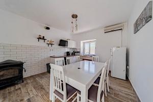 a kitchen with a white table and chairs and a refrigerator at Seaside holiday house Lumbarda, Korcula - 21301 in Lumbarda