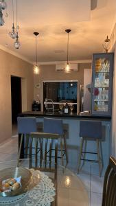 a kitchen with a bar with chairs and a table at Tropical Residencial in Iranduba