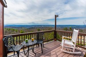 a deck with two chairs and a table and chairs at Mountain chalet w hot tub & private balcony in Augusta