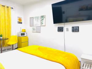 a bedroom with a bed with a yellow blanket at Imperial Stay BNB in Brooklyn