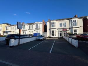 a parking lot with cars parked in front of buildings at Clifton Villa - Southport in Southport
