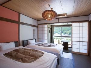 Rúm í herbergi á 桜 River Side Stay下呂温泉