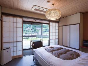 Rúm í herbergi á 桜 River Side Stay下呂温泉