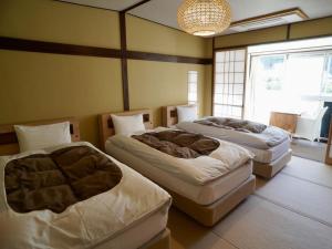 Rúm í herbergi á 桜 River Side Stay下呂温泉