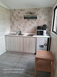 una cucina con lavello e microonde di Hotel Palmas de La Serena a La Serena