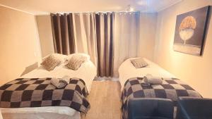 two twin beds in a room with a window at 1 Apartamento en Santiago en frente a Metro - Estadio - Hipodromo de Chile in Santiago