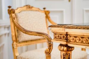 a table with a chair next to a table with at Hotel Bristol, A Luxury Collection Hotel, Warsaw in Warsaw
