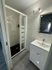 a white bathroom with a sink and a shower at Apartamentos Sol Mayor in Madrid