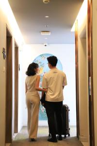a man and woman standing in a hallway with a suitcase at HOME Hotel in Ho Chi Minh City +101 photos