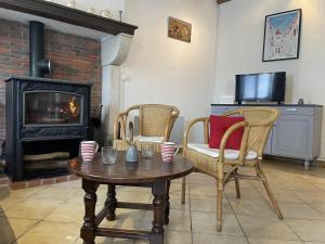 a living room with a table and chairs and a fireplace at Maison de ferme rénovée en pierre avec jardin, cheminée, WIFI, équipements bébé, animaux acceptés - FR-1-489-19 in Ébreuil