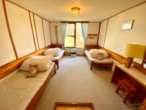 a room with couches and chairs in a room at Mashuko Youth Hostel in Teshikaga