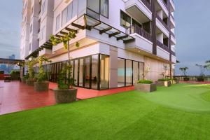 a building with a green lawn in front of it at Citadines Gatot Subroto Jakarta in Jakarta