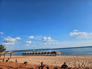 a sandy beach with umbrellas and the ocean at Casa de Praia Pindobal in Santarém
