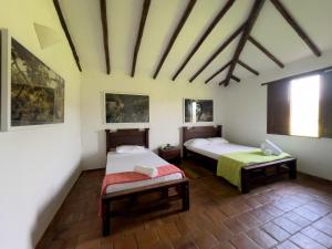 une chambre avec deux lits dans une pièce dans l'établissement Casa Villa Lolita, Barichara, à Barichara