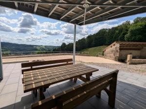 two wooden benches sitting on a patio with a view at Gîte Montagne avec Piscine Chauffée, Spa et Sauna - Les Roches - FR-1-589-656 in Le Val-dʼAjol