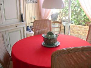 a red table with a hat on top of it at Chambres d'hôtes Issy-Paris in Issy-les-Moulineaux