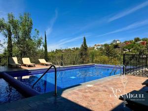 a swimming pool with two lounge chairs next to at Charming No Stairs Near DT Security Pool Parking in San Miguel de Allende