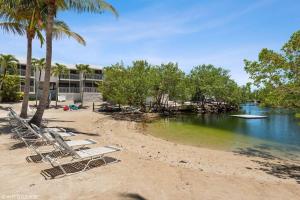 a group of lounge chairs on a beach at KAWAMA L4 in Key Largo, Beach, Lagoon, Pools, Tennis and Free Bikes in Key Largo