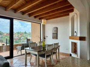 a dining room with a table and chairs and a fireplace at Charming No Stairs Near DT Security Pool Parking in San Miguel de Allende